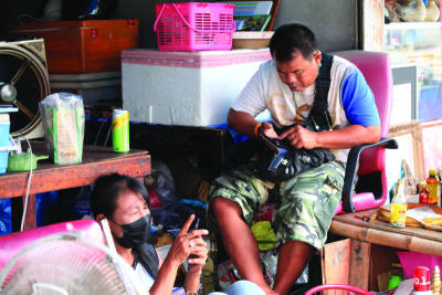 พ่อค้าแม่ค้ากำลังลงทะเบียน ดิจิทัลวอลเล็ต วันแรก ย่านคลองหลอด ถนนบุญศิริ เขต พระนคร