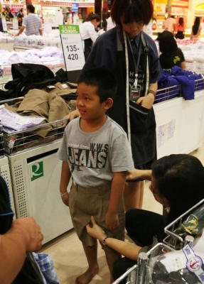 พ่อแม่กำลังเลือกซ ื้อชุดนักเรียน กางเกงนักเรียนในกับลูกในช่วงที่ใกล้จะเปิดเทอมที่ ห้างฟิวเจอร์ปาร์ครังสิต จังหวัดปทุมธานี