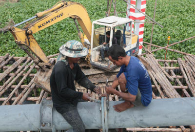 คนงานกำลังทำการรื้อถอนท่อน้ำประปาเก่าเพื่อทำการขยายถนนเข้าคลองสี่ใหม่