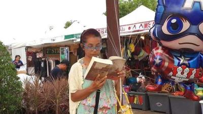 แม่ค้าหนอนหนังสือยืนขายลูกโป่ง สุดแปลกอ่านไปด้วยได้บรรยากาศ