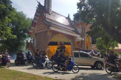 Young motorcyclists with revving engines escort the coffin of their teen friend